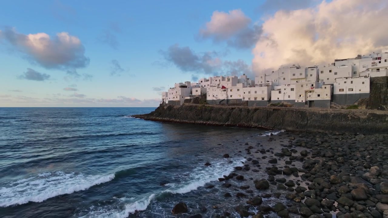 Ampia veduta aerea di El Roque, un gruppo di case bianche costruite su uno sperone di roccia vulcanica sopra il mare a Moya, Gran Canaria, Spagna