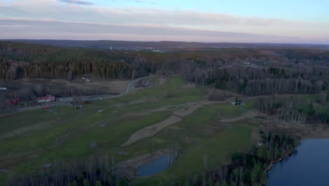 Imágenes-De-Drones-Invertidos-Que-Muestran-Un-Campo-De-Golf-Verde-Durante-El-Invierno-Mientras-Revelan-Un-Pequeño-Lago