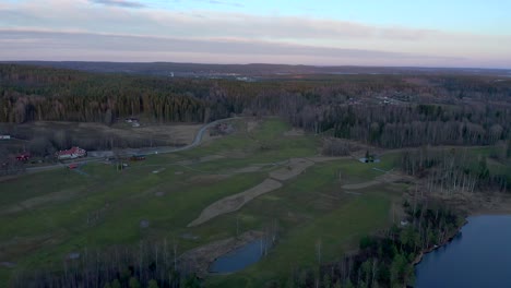 imágenes de drones invertidos que muestran un campo de golf verde durante el invierno mientras revelan un pequeño lago
