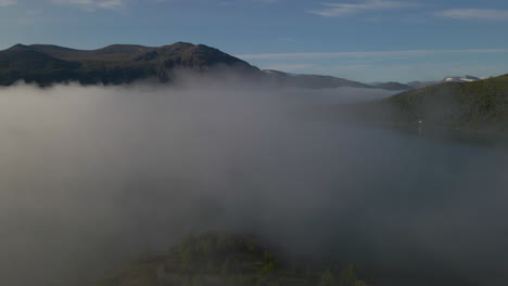 drone flying through cloud and fog surrounded by mountains and forests