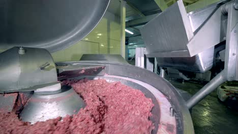 meat being minced at a plant.