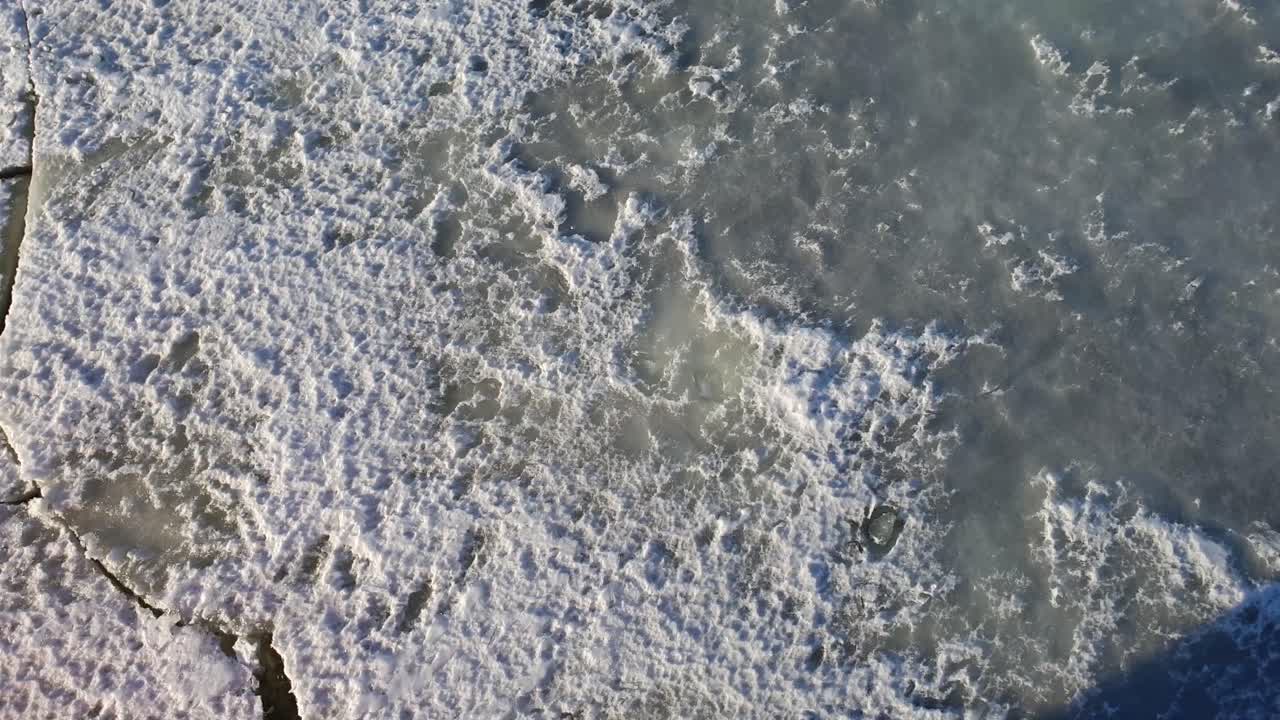Ice Breaking on surface of frozen water as the Icebreaker ship pass by at Lapland Finland. High Angle Shot