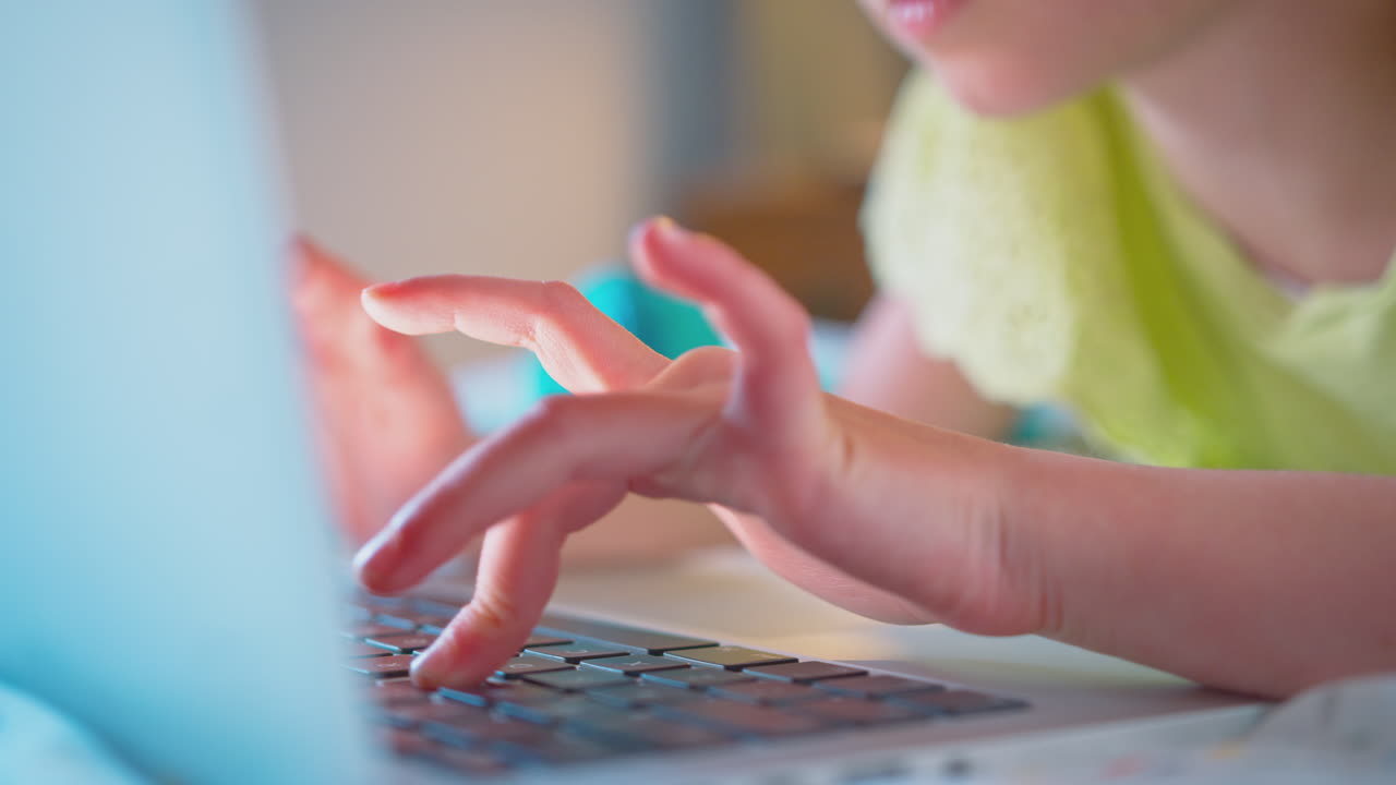 close up de una chica en el dormitorio acostada en la cama usando una computadora portátil para hacer la tarea