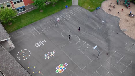 aerial shot of kids shooting hoops at an elementary school after hours