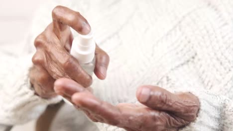 elderly person applying hand sanitizer