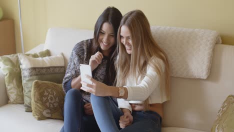 Dos-Mujeres-Jóvenes-Emocionadas-Leyendo-Un-Sms