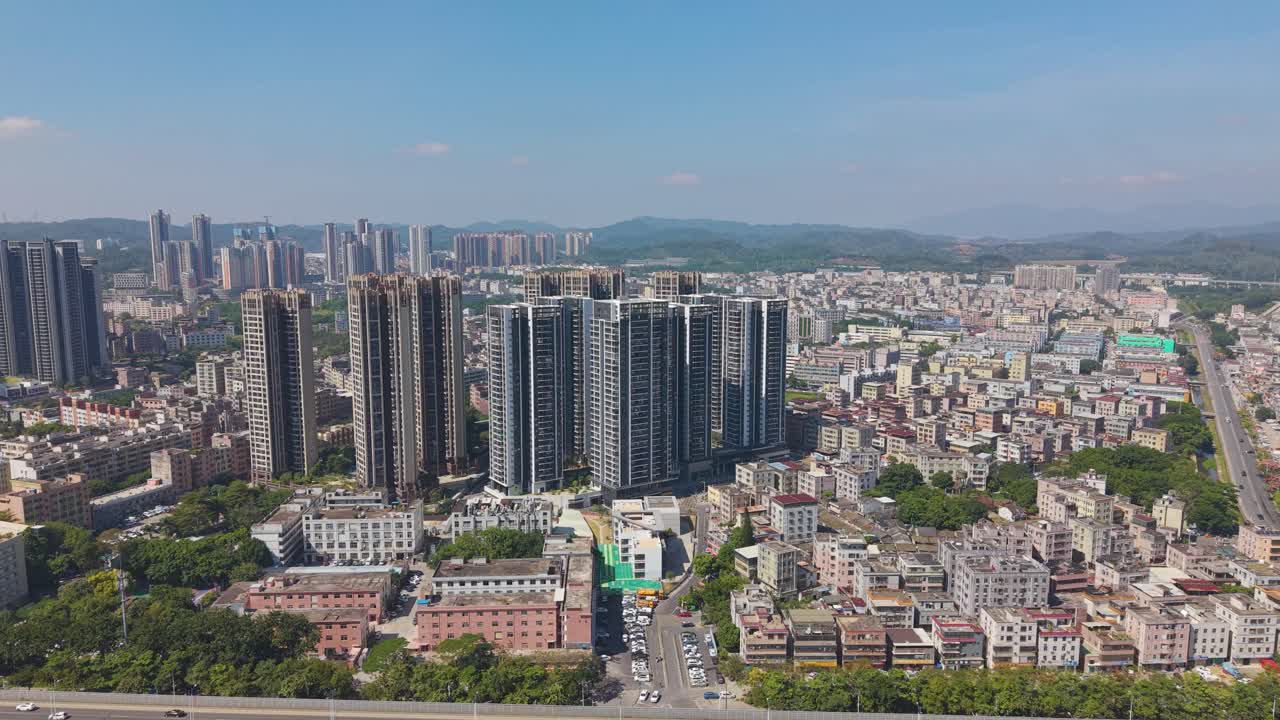 Pull out wide drone shot of the Shenzhen outskirts skyline. Captures the intense urban sprawl and development, China