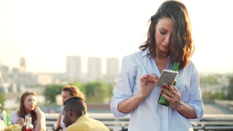 woman on rooftop party using smartphone