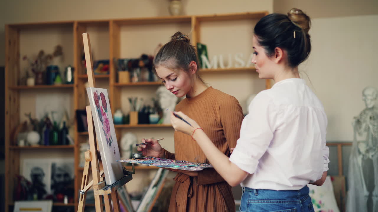 두 명의 여성이 미술 스튜디오에서 그림을 그리고 있습니다.