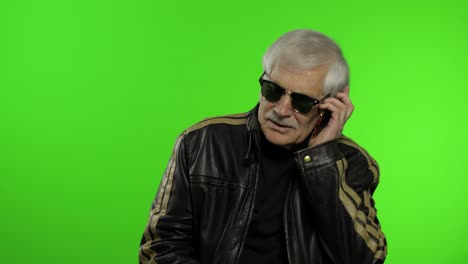 elderly stylish caucasian grandfather man dissatisfied talking on mobile phone