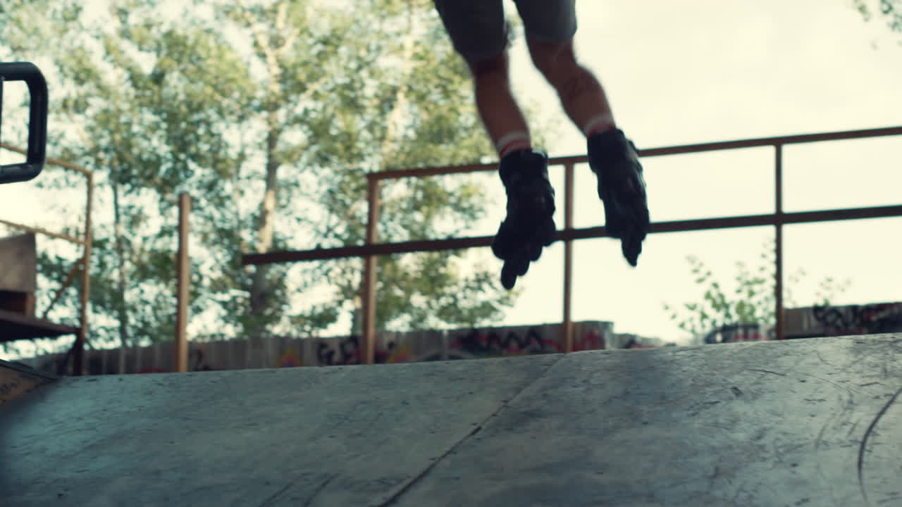 Hipster che esegue un trick di salto in uno skate park urbano. Adolescente che pattina in rampa.