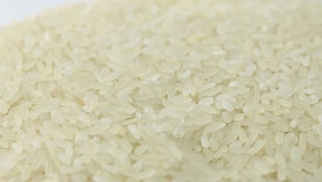 macro white raw rice texture, food background, vegetarian healthy eating product. rotating close up of a pile of raw rice