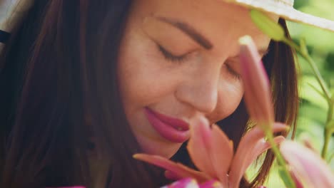 woman with brown hair wearing a hat gently touching flowers in a vibrant garden setting