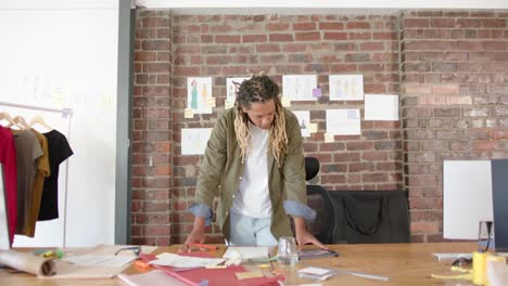 Portrait-of-happy-biracial-male-designer-using-tablet-in-fashion-design-studio-in-slow-motion