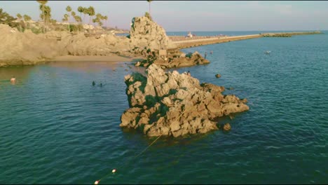 drone view of a big rock at newport beach