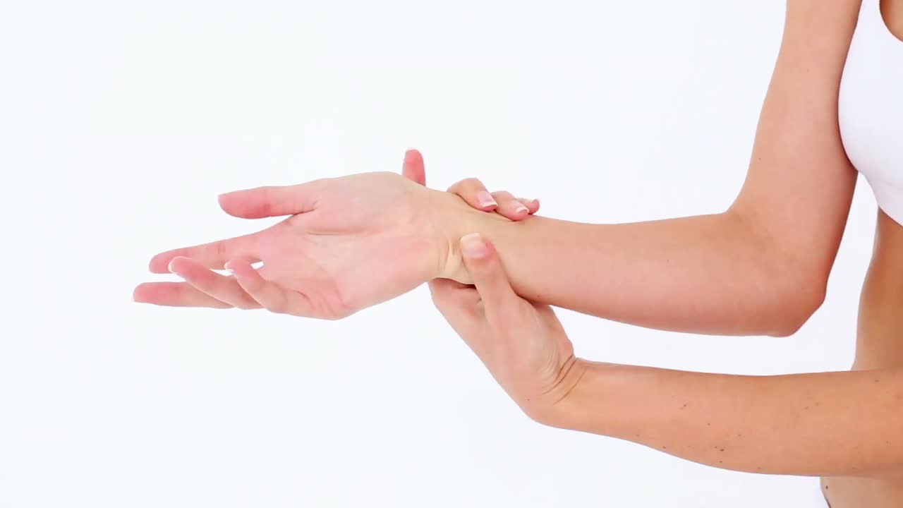 Premium stock video Fit model in sports bra holding her sore wrist