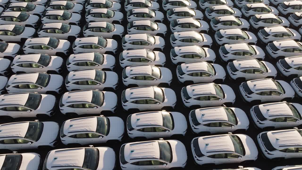 Flying over countless mass production vehicles parked near each other,