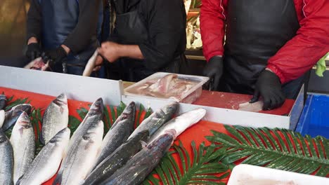 fishmonger cleaning fish at a market stall