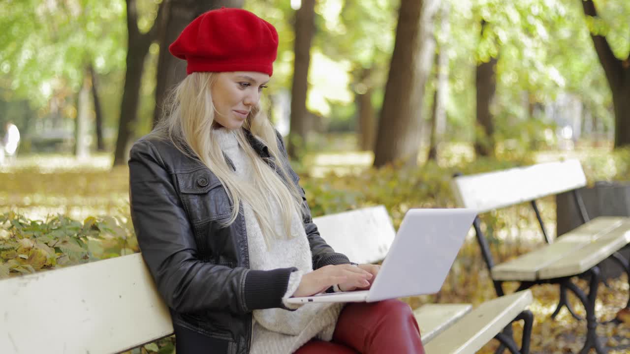 Woman using laptop in autumn park