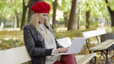 Woman-using-laptop-in-autumn-park