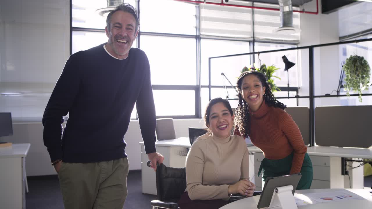 Colegas de trabalho diversos usando tablet, reunidos em uma mesa branca em um escritório de plano aberto, revisando um projeto