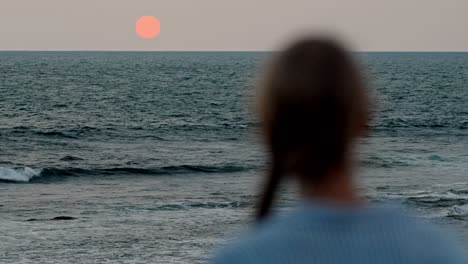 a serene moment in galle, sri lanka, as a woman gazes at the vast ocean during a breathtaking sunset.