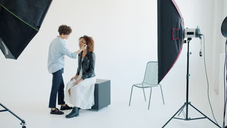 makeup artist applying makeup to model in a studio setting