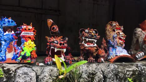 colourful cartoon souvenir guardian dog statues displayed on a wall