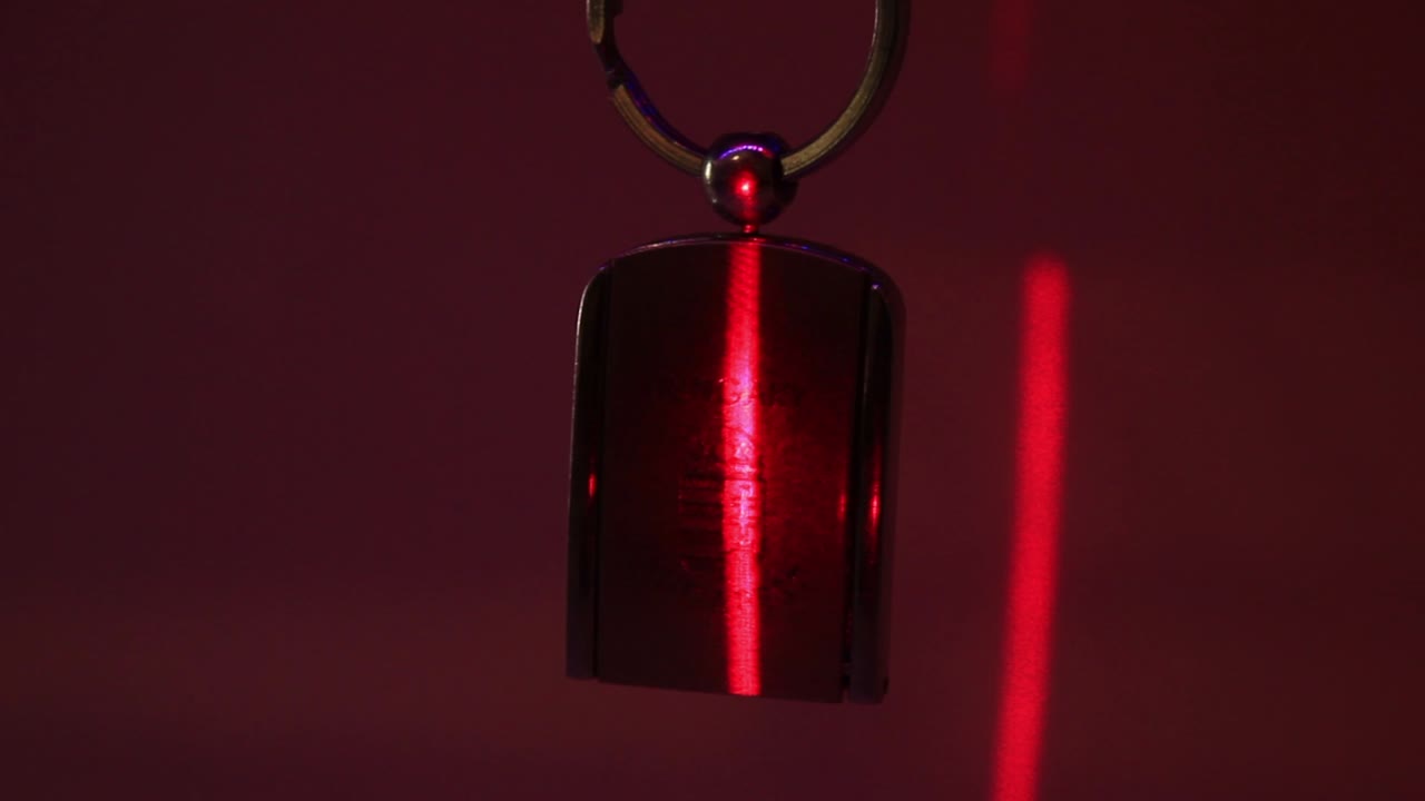 Primo piano di un portachiavi souvenir in metallo dell'Ungheria e della luce laser verticale.
