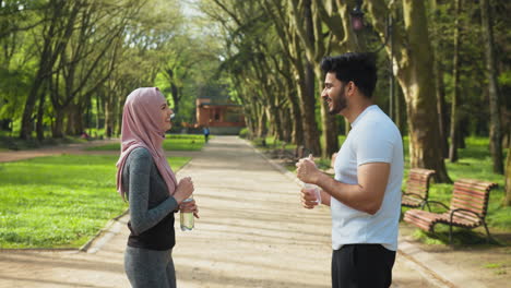 couple enjoying a break in the park after a workout