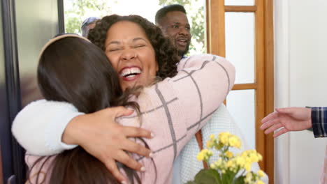 Happy-diverse-couple-receiving-guests-and-friends-in-sunny-home