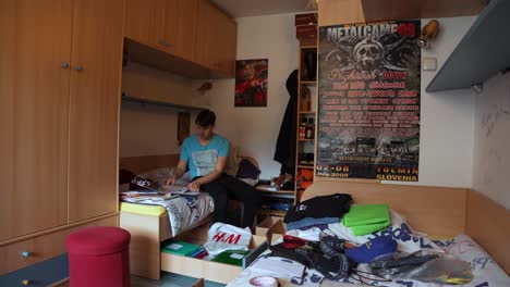 a young man is working hard to put everything in order and tidy up his room