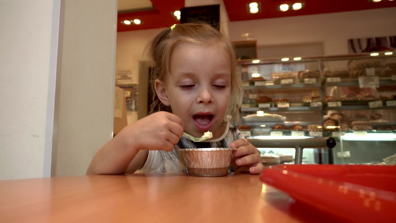 la niña está comiendo postre.