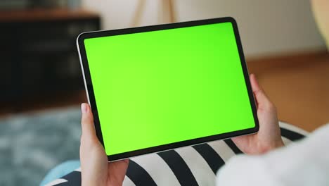 close up de mujer sosteniendo en las manos una tableta digital con pantalla verde para internet en línea, pantalla clave de croma para publicidad.