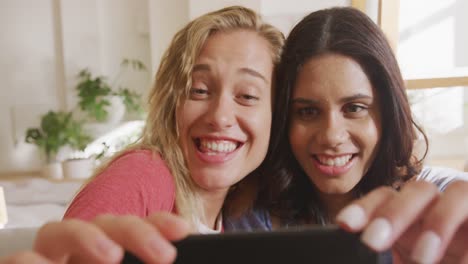 Two-young-woman-friends-taking-a-selfie-indoors