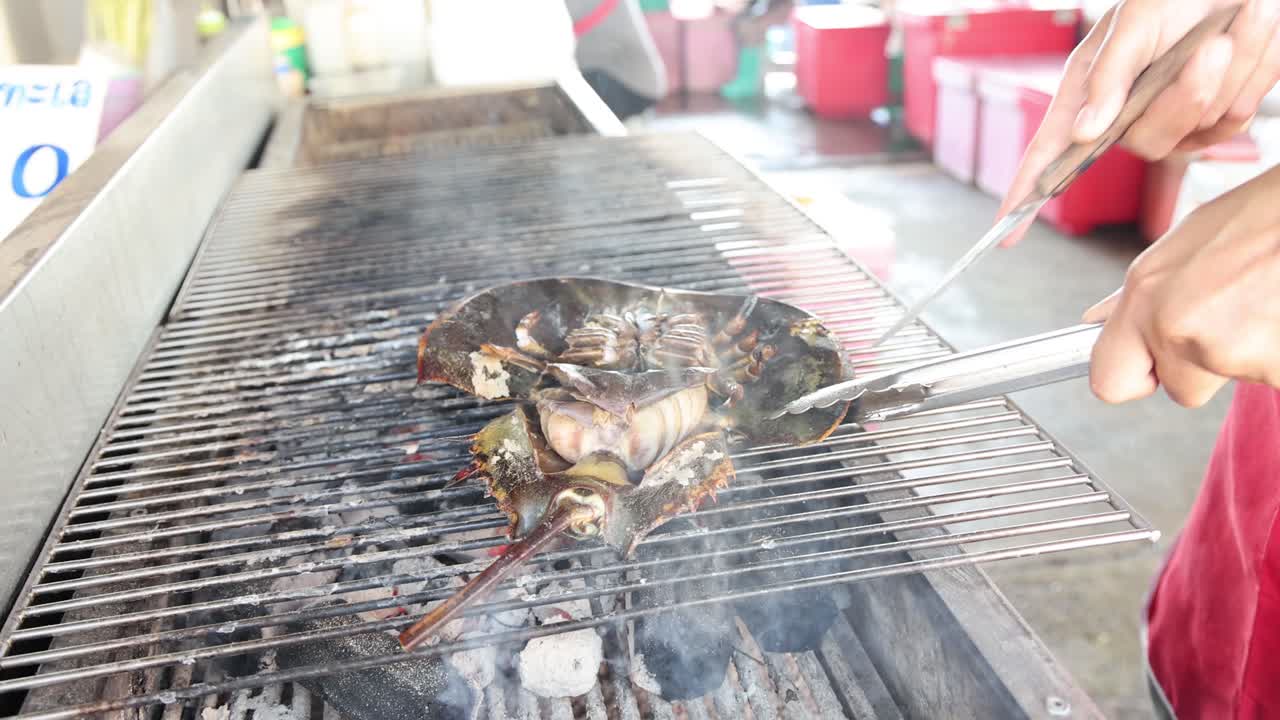 바베큐 그릴에서 말발 크래브를 요리하는 것.