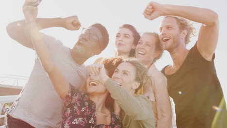 Jóvenes-Amigos-Sonrientes-Posando-Juntos-Para-Un-Selfie-En-Una-Pasarela-Al-Aire-Libre