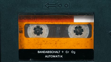 the vintage yellow audio cassette in the tape recorder rotates