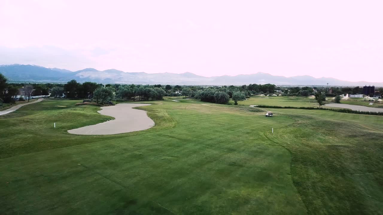 드론이 럭셔리 그린 골프 코스에서 페어웨이를 날아다니고 있습니다.
