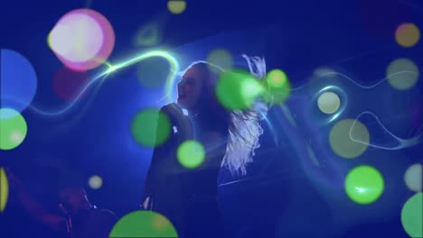 multicolored glowing spots of lights against woman singing in a concert