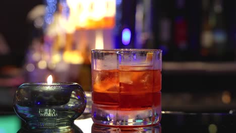 cocktail with ice on a vibrant bar counter