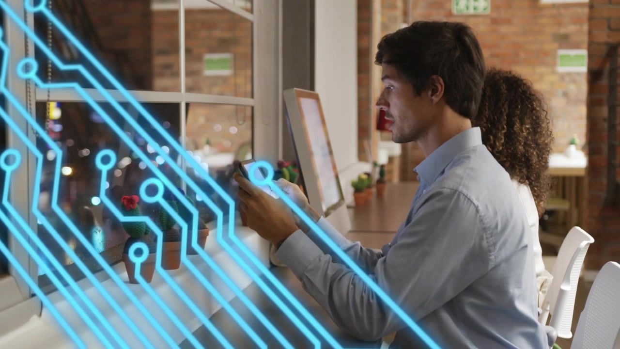 Man manipulating handheld touchscreen at window desk, activating blue circuitry overlay for AR demo
