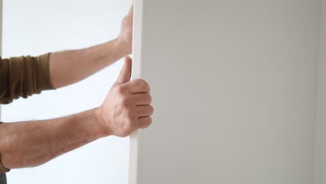 man installing a white cabinet