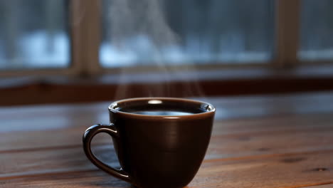 steaming hot coffee mug on a wooden table