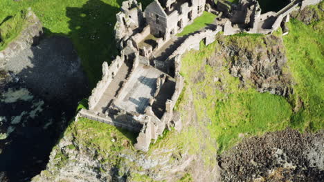 Toma-Aérea-Giratoria-Del-Castillo-De-Dunluce-En-Irlanda-Durante-Un-Día-Soleado