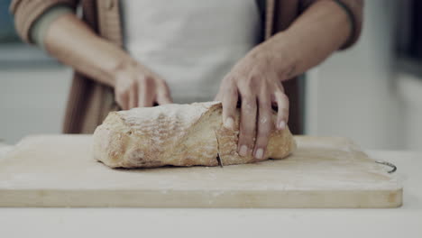 bread, knife and hands in kitchen