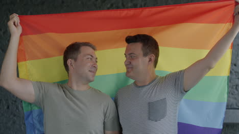 two men holding a pride flag