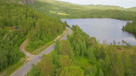 Vista-Aérea-Por-Drones-De-Vehículos-Que-Viajan-Por-Una-Carretera-De-Montaña-En-El-Fiordo,-Noruega