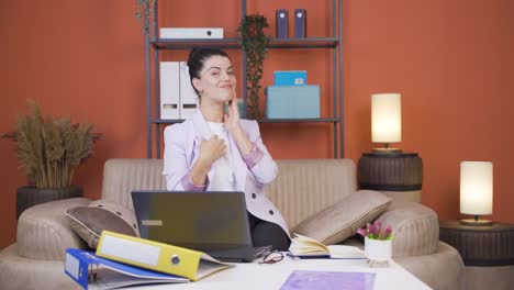 Home-office-worker-young-woman-looks-at-camera-with-happy-and-smiling-face.