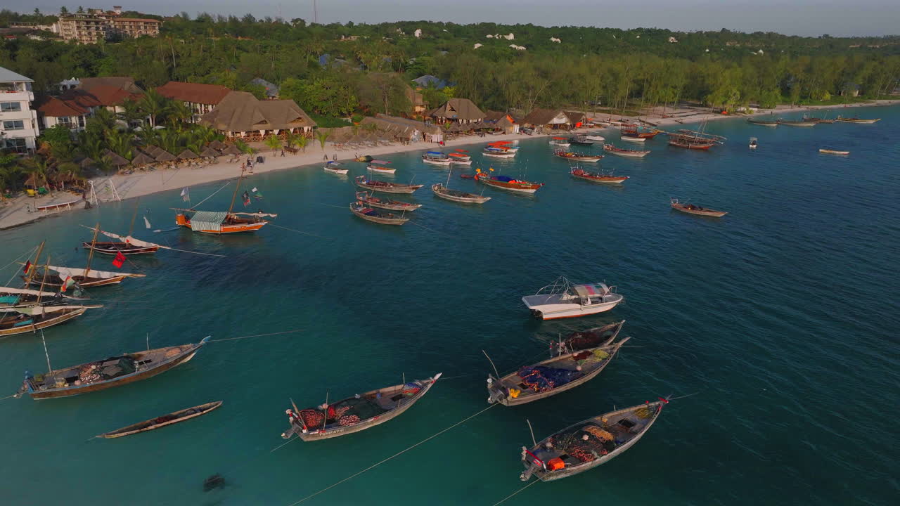 vista aérea de una playa de arena con barcos y gente de fondo, aldea de kendwa, zanzíbar, tanzania